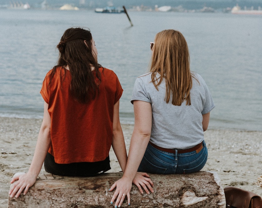 دو دختر غریبه در حال صحبت کردن با یکدیگر در کنار ساحل